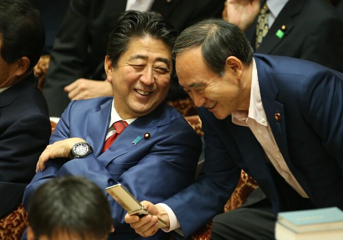 衆議院予算委員会で菅義偉官房長官（右）と談笑する安倍晋三首相（当時）＝2016年9月29日、東京・国会内