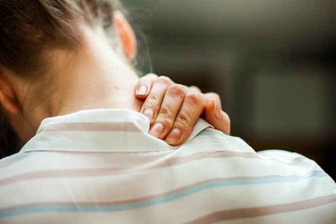 首をおさえる女性