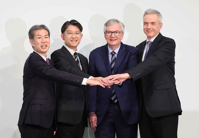 経営統合に関する記者会見後、笑顔で写真に納まる(左から)日野自動車の小木曽聡社長、トヨタ自動車の佐藤恒治社長、ダイムラートラックのマーティン・ダウム最高経営責任者(CEO)、三菱ふそうトラック・バスのカール・デッペン社長=2023年5月30日、東京都港区