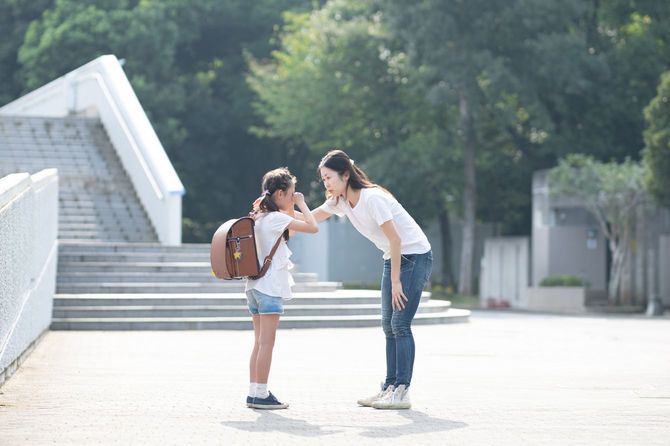 泣いている女の子を励ましている女性
