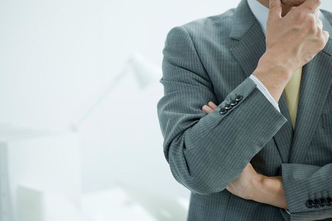 腕組みをして考えているビジネスマン