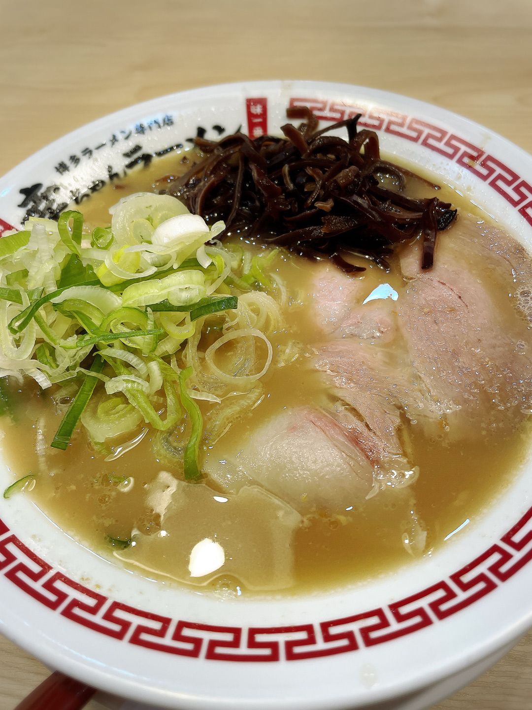 バンコク店の「豚骨ラーメン（190バーツ）」。福岡ではおなじみの青ねぎときくらげはトッピングで追加できる。円換算で一杯855円と日本よりも少し高い価格設定になっている