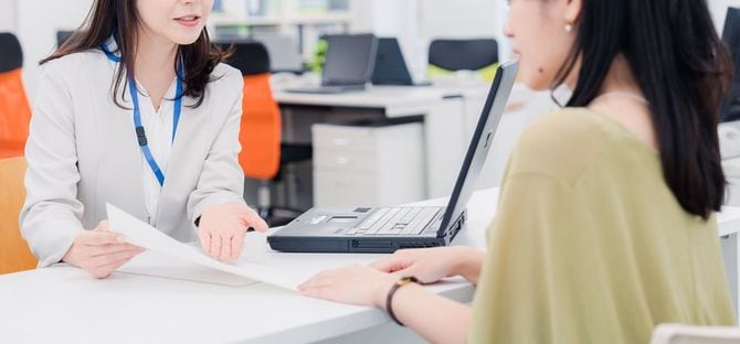 カウンターで書類の説明をする女性
