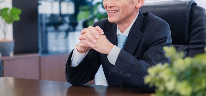 役員室で笑顔の企業幹部