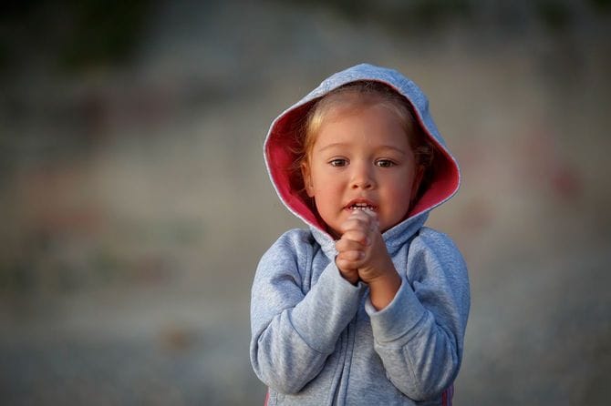 両手を握りしめ、彼女の欲望を満たすために懇願するような女の子が立っています。