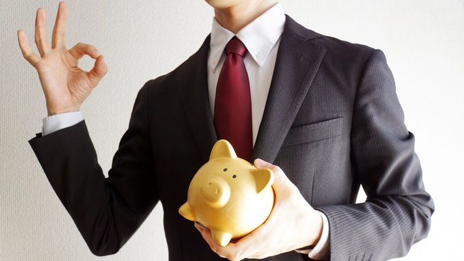 貯金箱を持つビジネスマン