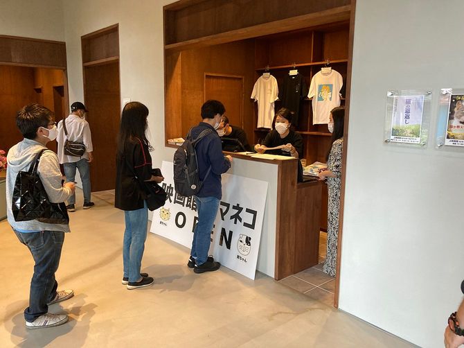 杮落し。受付に並ぶ来場者。