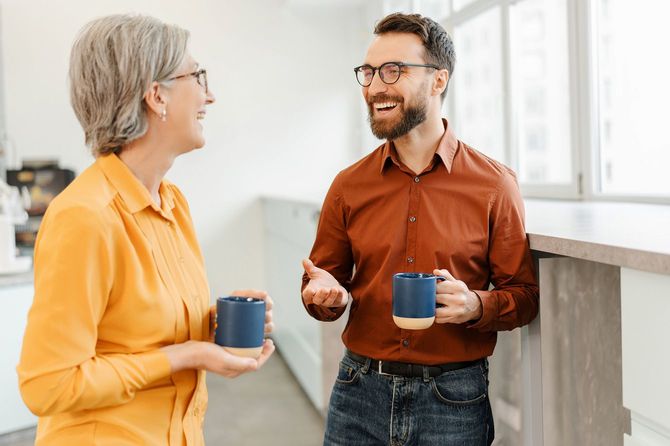 オフィスでコーヒーを飲みながら話をする2人