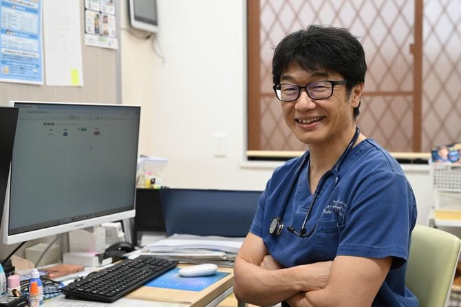 大阪・河内長野の診察室で笑顔を見せる水野宅郎さん