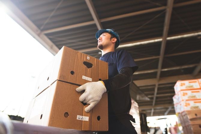 倉庫で荷物を運ぶ作業員
