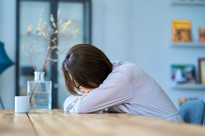 テーブルにうつぶせる女性