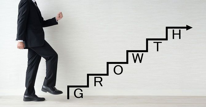 「GROWTH」と書かれた階段を上るビジネスマン
