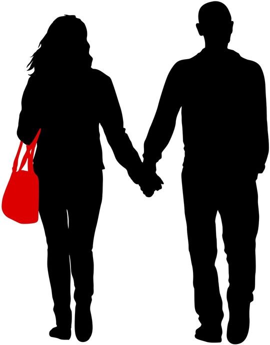 手をつないで歩いている男女カップルのシルエット