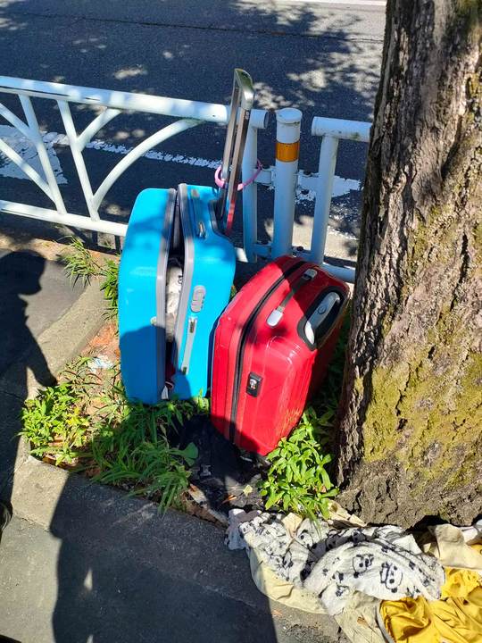 参宮橋駅近くのガードレールにくくりつけられたキャリーケース。