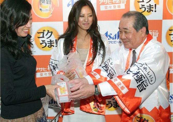 「極旨（ゴクうま）」の発表会で特製グラスを配布するアサヒビールの荻田伍社長（右）＝2006年10月16日午後、東京・丸の内