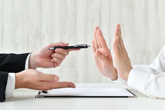 契約を勧めるビジネスマンと断る顧客