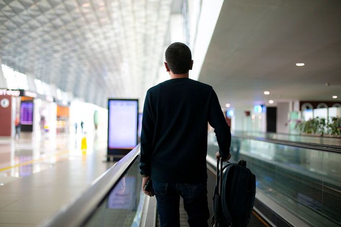 動く歩道で移動するビジネスマン