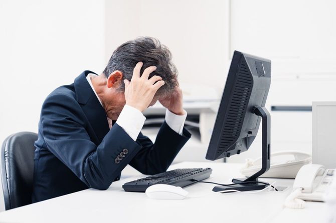 頭を悩ませる中間管理職ビジネスマン