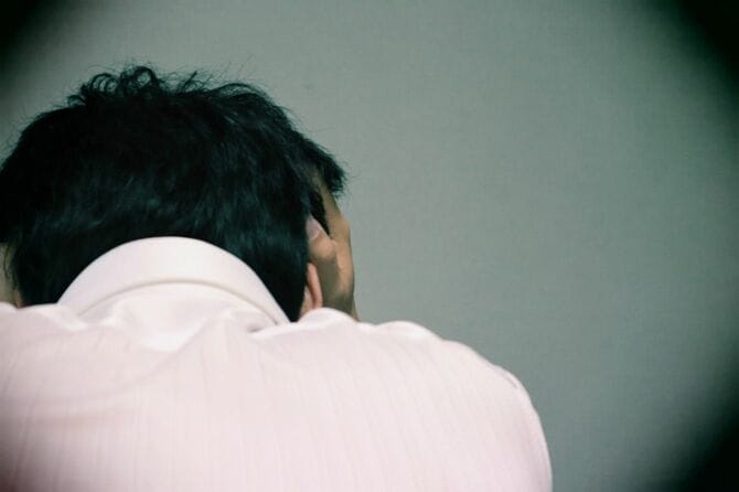 頭を抱えて落ち込むビジネスマン