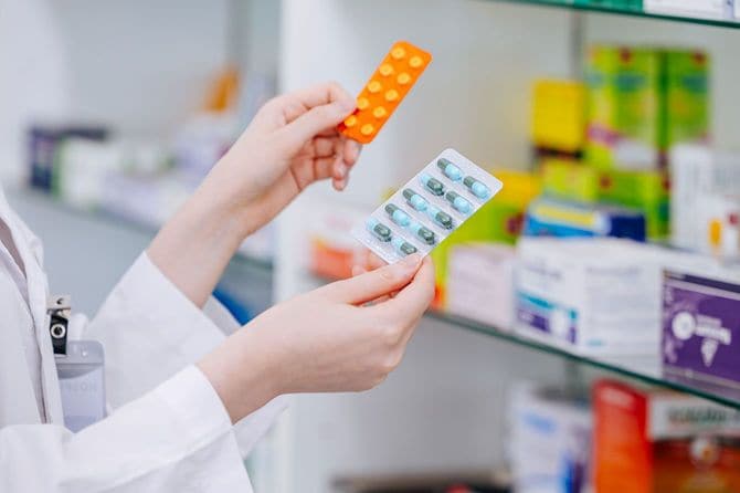 薬局で薬を見比べる薬剤師