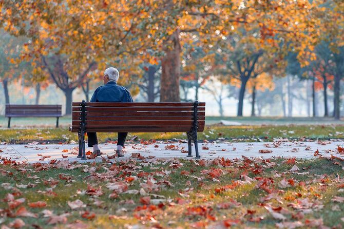 公園のベンチに座っている孤独なシニア老人