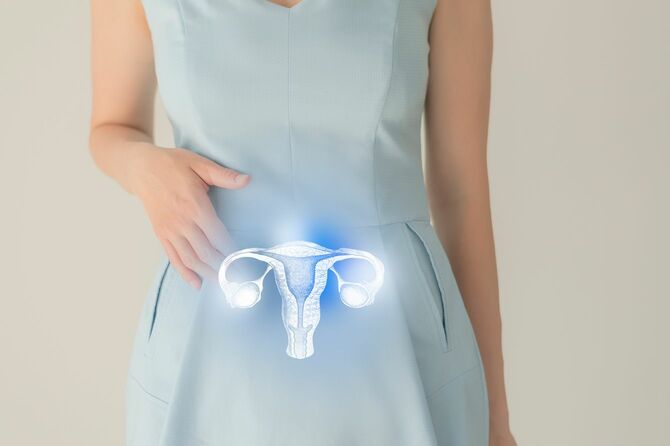 水色のワンピースを着用した女性の腹部に子宮のイラスト