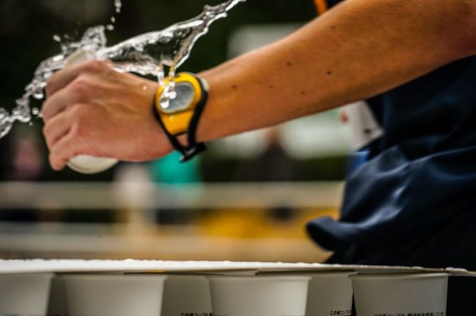 給水所で水の入ったコップを勢い良く手にするランナー