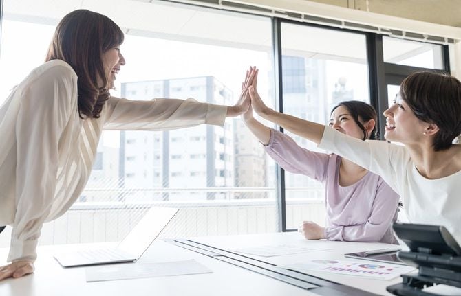 オフィスでハイタッチする女性社員たち