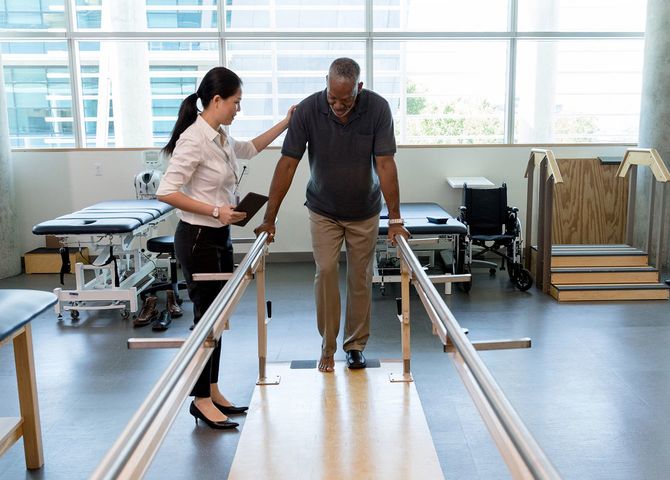 女性理学療法士のケアは、リハビリセンターで脳卒中の犠牲者を助けます