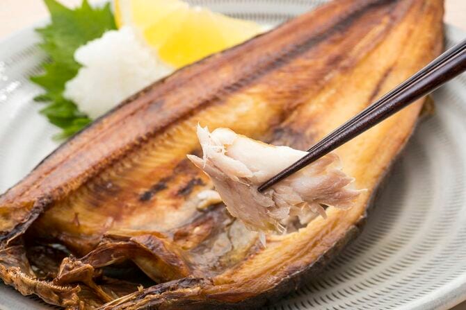 魚の干物の身を箸でつまんでいる写真