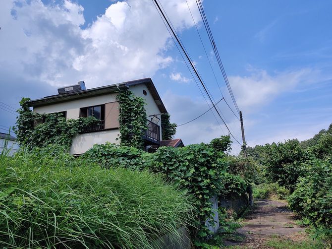 窓ガラスが開け放たれたまま放置されている空き家。適切に管理すれば売れるはずの家屋でも、未管理のまま放置されている。（千葉県成田市吉岡）