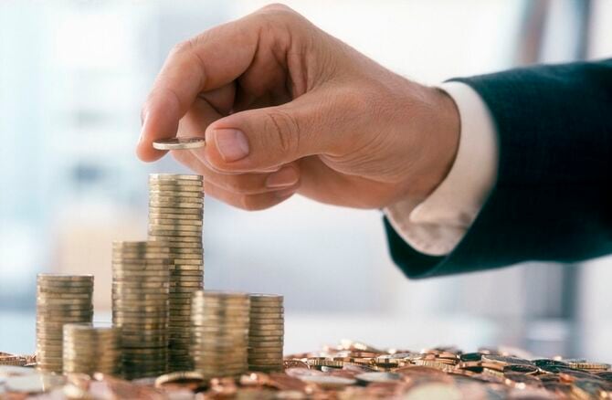 男性の手は、ユーロ硬貨を積み重ねています