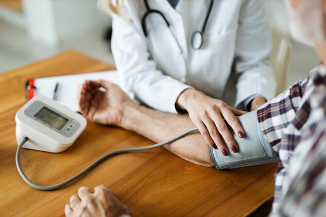 シニアの血圧測定中の女性医師