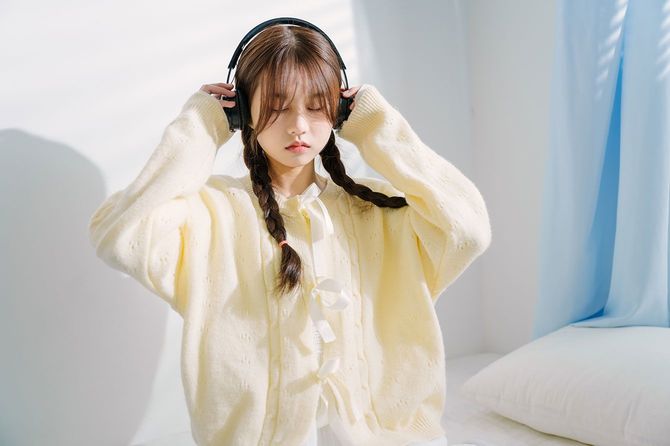 ヘッドホンで音楽を聴いている女性