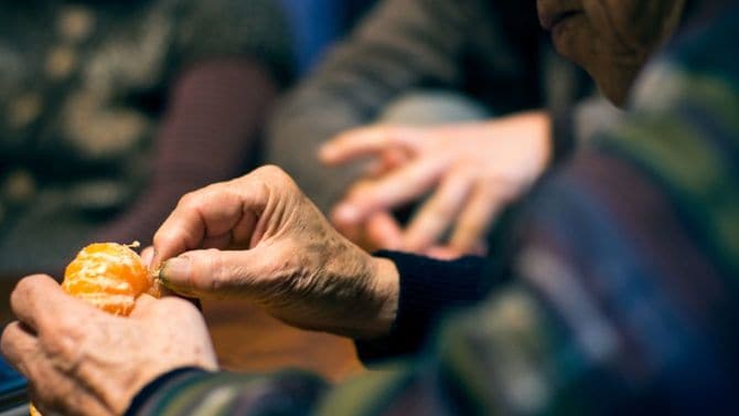 みかんをむくシニアの手元