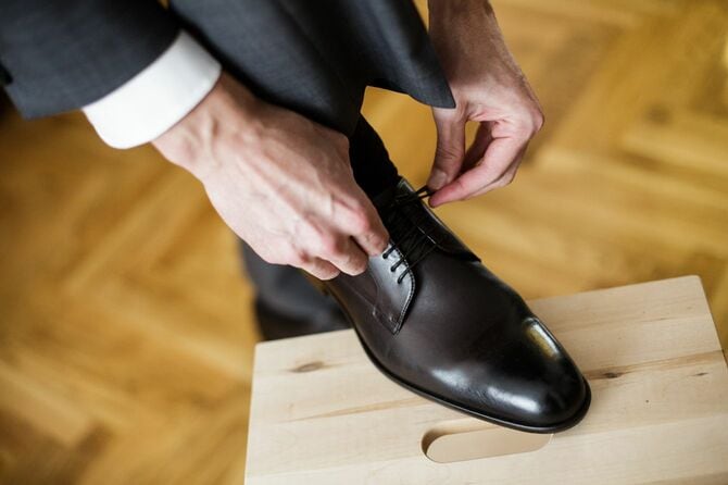 革靴の靴紐を絞めている男性の手元