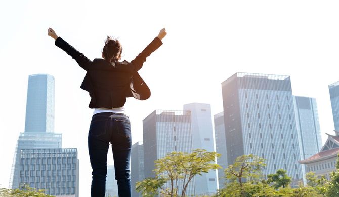 腕を上げて立っているビジネスウーマン