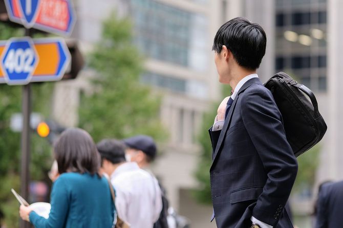 路上で信号を待っている若いビジネスマン