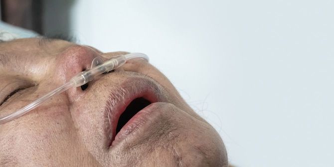 自宅での呼吸を助けるために鼻呼吸チューブを持つ高齢の女性