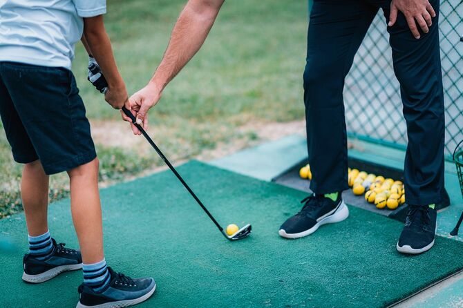 ゴルフレッスン。若い男の子にゲームレッスンを与えるゴルフインストラクター。
