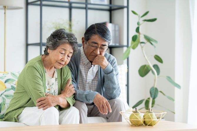 悩んでいる様子の年齢を重ねた夫婦
