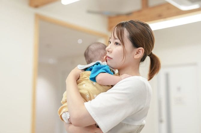 赤ん坊を腕に抱いている女性
