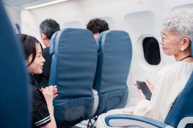 高齢のお客様を案内する客室乗務員