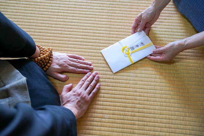 僧侶にお布施を渡すイメージ