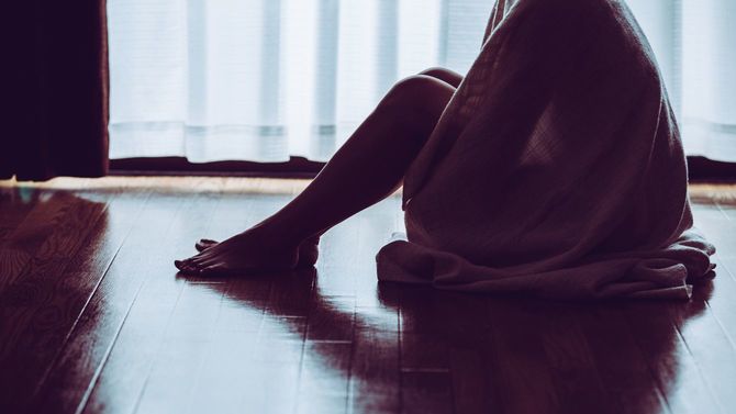 窓際に座って孤独な女性