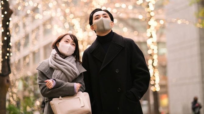 ライトアップされた街路樹をみるカップル