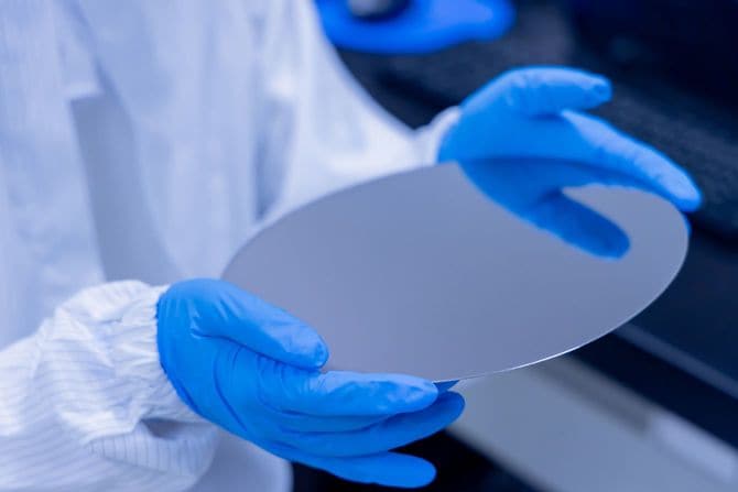 技術者がシリコンウェハを手に取る様子