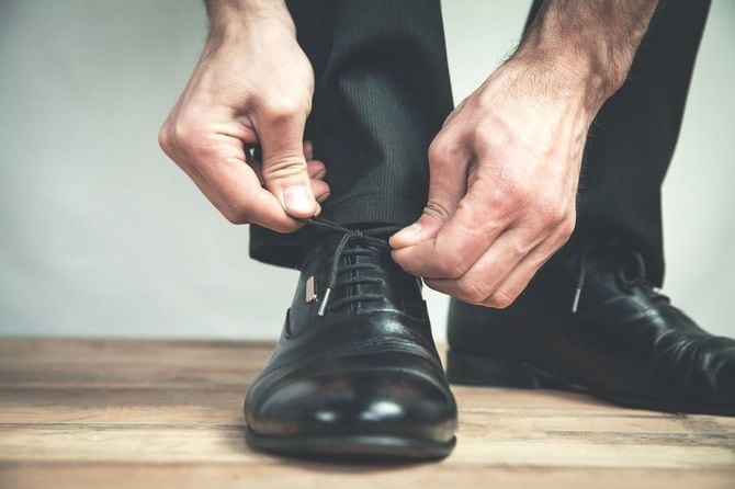 革靴の紐を結ぶ人