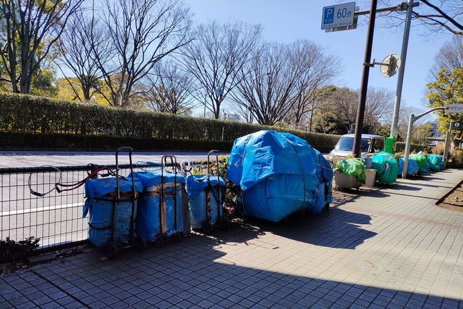 代々木公園横の歩道に並んだホームレスの荷物