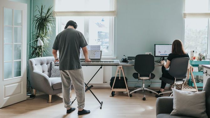 ロックダウン中にシンセを弾く夫とPCに向かう妻